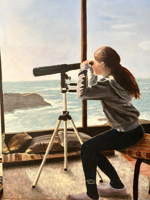Woman sitting at a beachfront window looking at the ocean with a telescope.